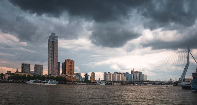 Weer Rotterdam met donkere buienlucht boven skyline en nat verkeer richting Gouda