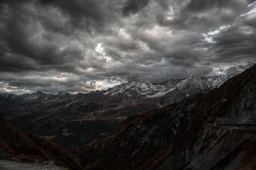 Donkere wolken en fileverkeer in een bergdal tijdens noodweer Alpen