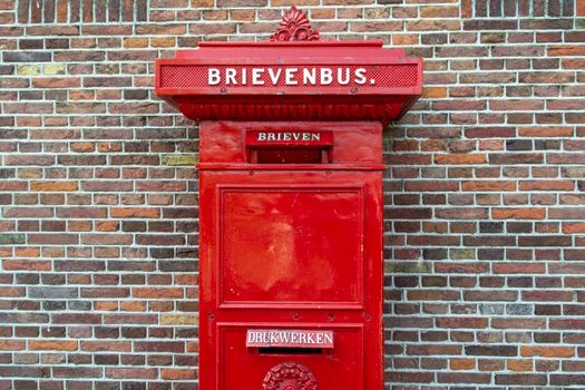 Brievenbus Oudgouda in de binnenstad bij een winkelstraat en haltebord